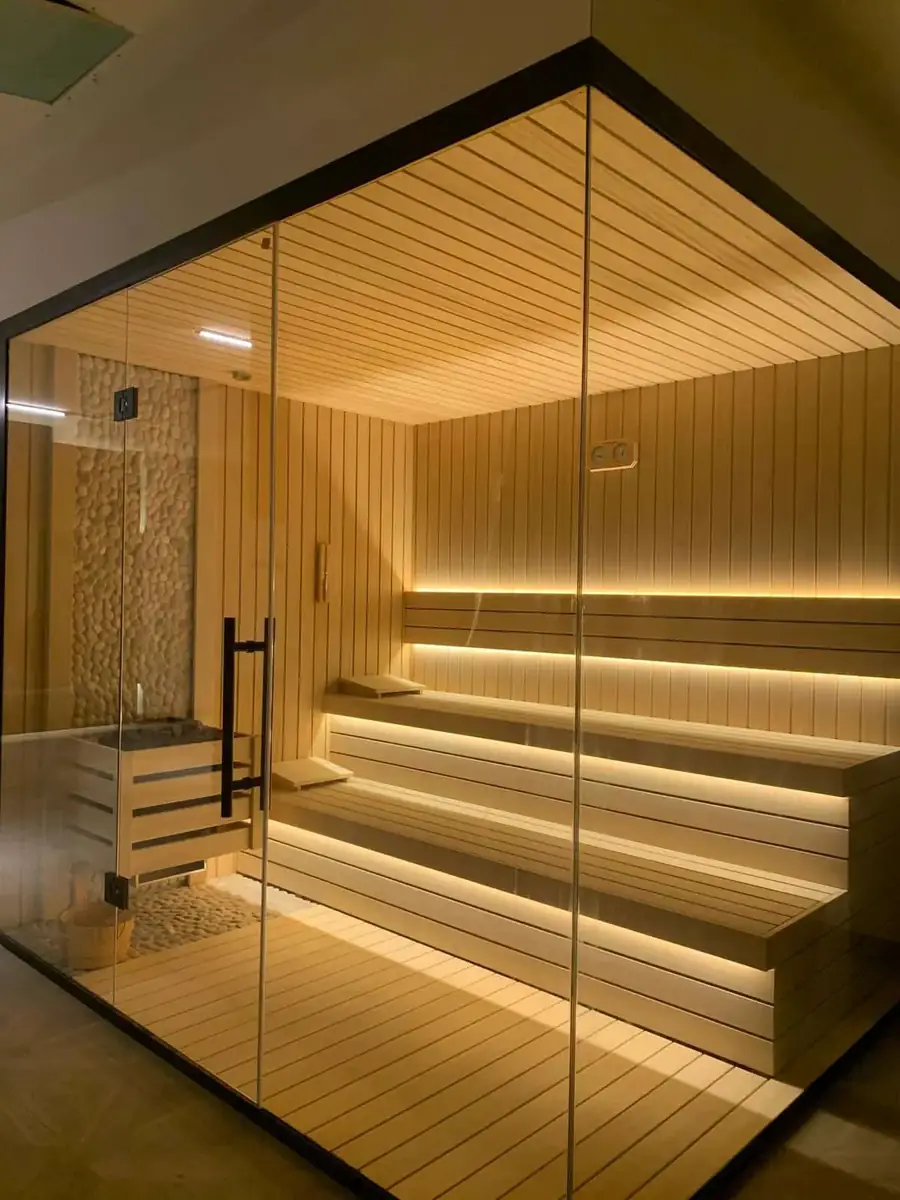 Private villa wellness suite: glass-fronted sauna with tiered LED-lit benches