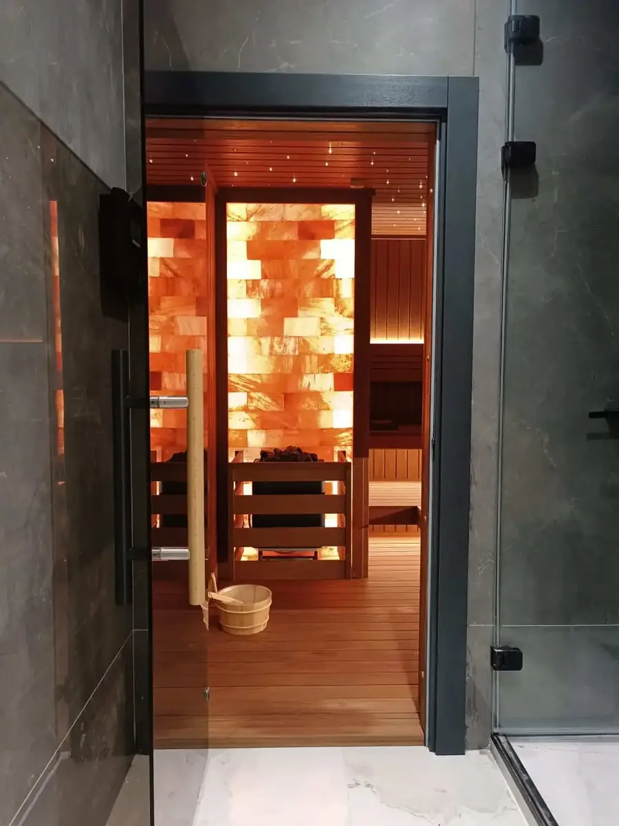Entrance to a private villa sauna, its salt wall visible through the glass door