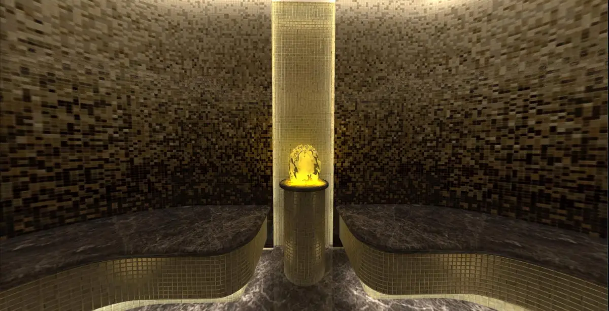 Steam room with gold mosaic walls, contoured benches and a backlit central column